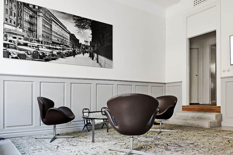En bild från entren till showroomet. På bilden syns tre fotöljer, ett soffbord och en tavla över Stockholm.